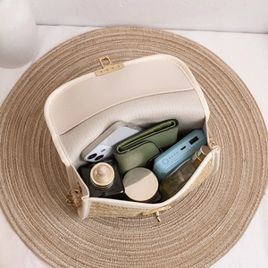 Straw woven crossbody bag in beige with gold lock showing spacious interior storage