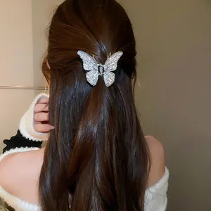 Elegant silver butterfly hair claw clip with rhinestones worn on a ponytail