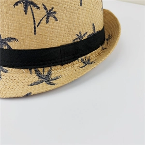 Close-up of a straw fedora hat featuring a woven texture and tropical coconut tree patterns