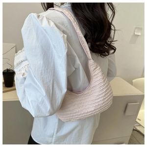 Pink pleated dumpling bag with soft bubble texture shown on a female model shoulder