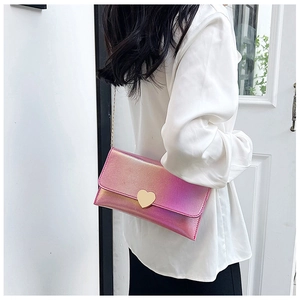 Detail of pink gradient laser handbag featuring a gold heart-shaped metal clasp and chain