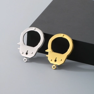 Detailed view of silver and gold handcuff-shaped metal pendants for jewelry making