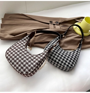 Detail of houndstooth hobo bags in brown and black with leather straps and gold chains