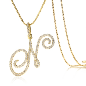 Détail du pendentif lettre N cursive en or avec zircons cubiques sur une chaîne box