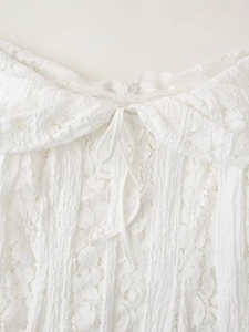 Détail de la robe en dentelle blanche avec cordon de serrage et texture fine