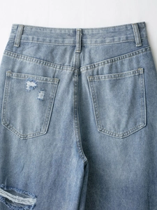 Dettaglio dei jeans strappati azzurro chiaro a vita alta con tasche posteriori e strappi