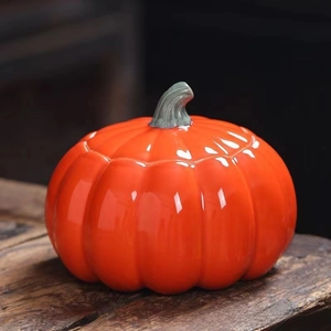 Dettaglio di un mini contenitore per tè in ceramica a forma di zucca arancione lucida