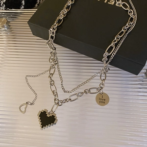 Detail of double-layer necklace featuring a black pixel heart and engraved I love you tag