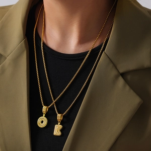 Double layered gold necklace with crystal paved letter O and K pendants on box chains