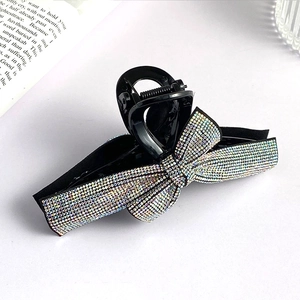 Sparkling rhinestone bow hair claw clip in black plastic for elegant updo hairstyles