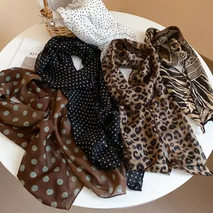 Polka dot and leopard print chiffon scarves displayed on a table with decor
