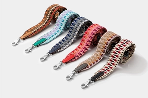 Array of colorful woven bag straps with leather ends and silver metal hardware buckles