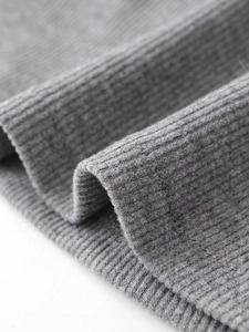 Macro shot of grey ribbed knit fabric texture showing the soft material and vertical patterns