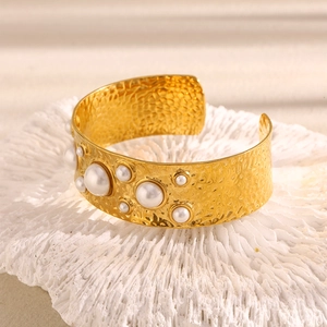 Macro shot of 18K gold plated wide cuff bracelet with hammer texture and white pearls