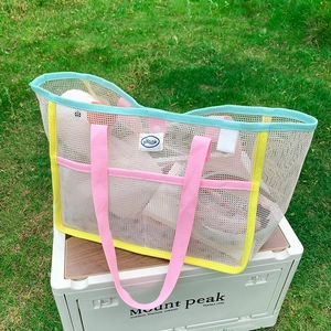 Detail of colorful woven handles and large capacity mesh storage on this beach tote bag