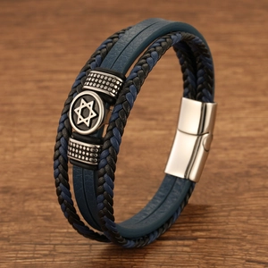 Macro shot of Star of David charm on multi-layer blue leather and woven steel bracelet