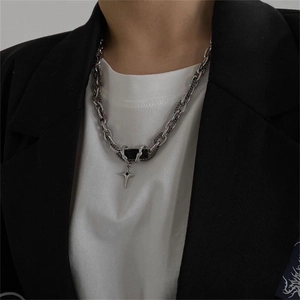 Men's silver layered necklace with black rectangle and cross pendant on a model