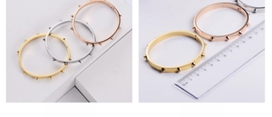 Detail view showing three colors of spiked bracelets and a 6cm diameter measurement