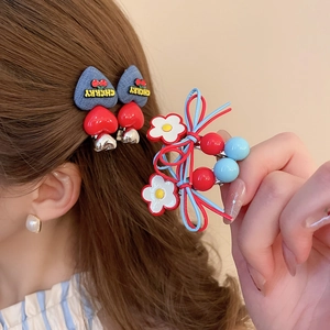 Detail view of denim texture heart hair clips with cherry charm and woven floral hair tie