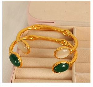 Detailed macro view of vintage open bangles with oval cat eye stones in jewelry box