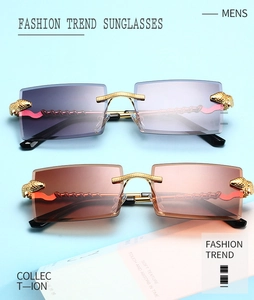 Close-up of rimless square sunglasses with gold panther head metal accents on temples