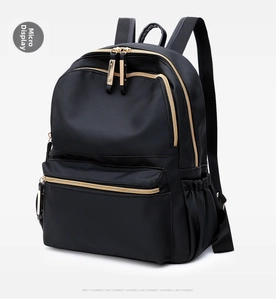 Side view detail of black Oxford fabric backpack featuring premium gold zippers and pockets