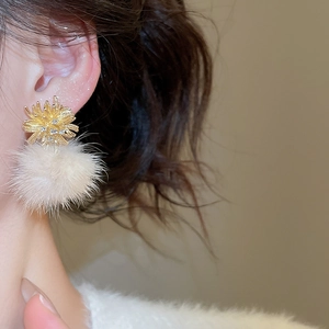 Detail showing gold firework stud with sparkling zircon and soft white plush pompom