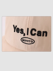 Close-up of the 'Yes, I Can' black embroidery on a beige cotton kids bucket hat