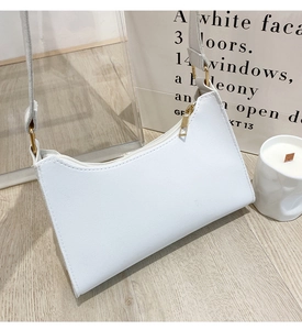 Detail of white embroidered shoulder bag featuring smooth PU texture and gold zipper