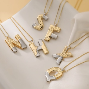 Two-tone gold and silver alphabet pendant necklace set with unique textured metal finish