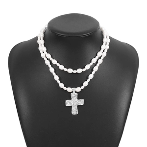Double-layered pearl necklace with a vintage textured silver cross pendant on a bust
