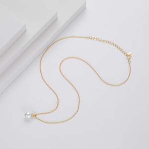 Detailed view of white pearl pendant with crown setting on a gold 925 silver chain