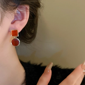 Detail view of model wearing asymmetric square and round tortoiseshell acetate earrings