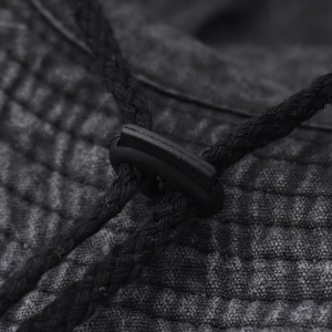 Detail of adjustable windproof drawstring buckle on black outdoor cotton bucket hat