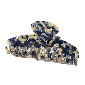 Detailed macro view of large acetate hair claw with blue and cream marble texture finish