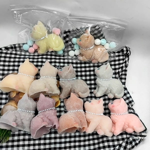 Detailed view of colorful squishy toy cats with pearl collars on checkered fabric