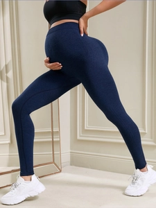 Detail of high-waisted maternity yoga leggings showing elastic support fabric in navy blue