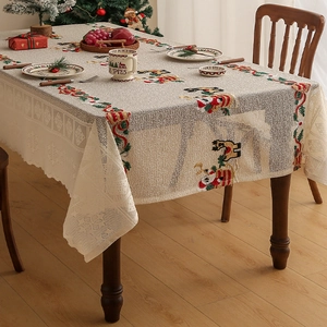 Dettaglio di Babbo Natale e renne ricamati su una tovaglia natalizia in pizzo stile vintage