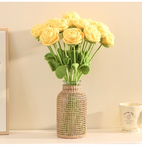 Detail of yellow handmade crochet roses with green leaves in a glass vase decor