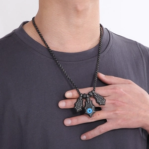 Macro detail of punk style evil eye pendant with blue resin eye on stainless steel chain