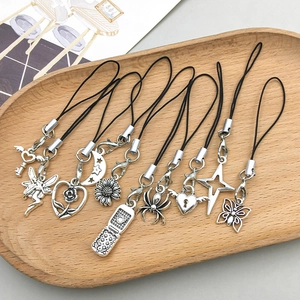 Detailed collection of vintage silver alloy charms featuring spiders and moon in a wood tray