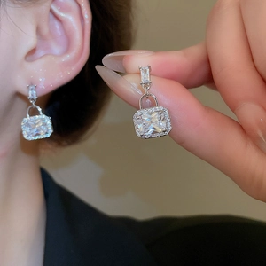 Detail view of square zircon drop earrings featuring silver needles and elegant geometric design