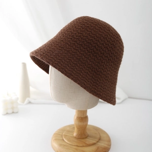 Close-up of a dark brown knitted bucket hat with thick textured wool on a mannequin
