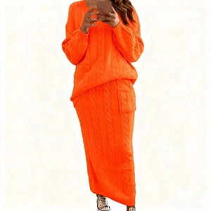 Détail d'un ensemble en maille orange fluo montrant la texture tressée et la matière