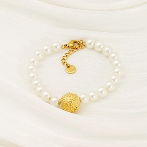 Bracelet perles en acier inoxydable doré avec billes texturées sur soie crème