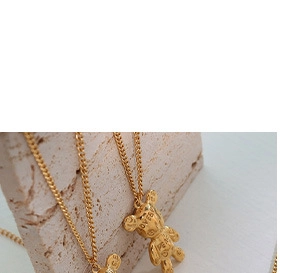 Detail of a golden 3D bear pendant necklace with LOVE engraving on art base