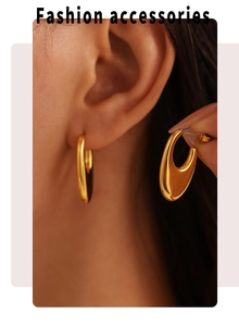 Close-up of polished gold U-shaped drop earrings with high-gloss metallic texture