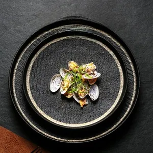 Macro shot of matte black ceramic snack plates with a modern textured stone-like finish