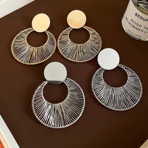 Exaggerated C-shaped circular drop earrings with metallic wire wrapping in gold and silver