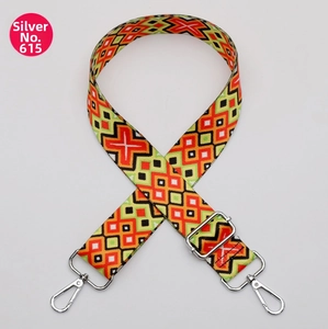 Detail of colorful geometric woven bag strap with silver metal swivel snap hooks